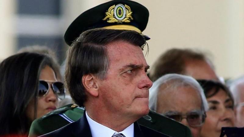 Foto de Jair Bolsonaro com chapéu militar ao fundo