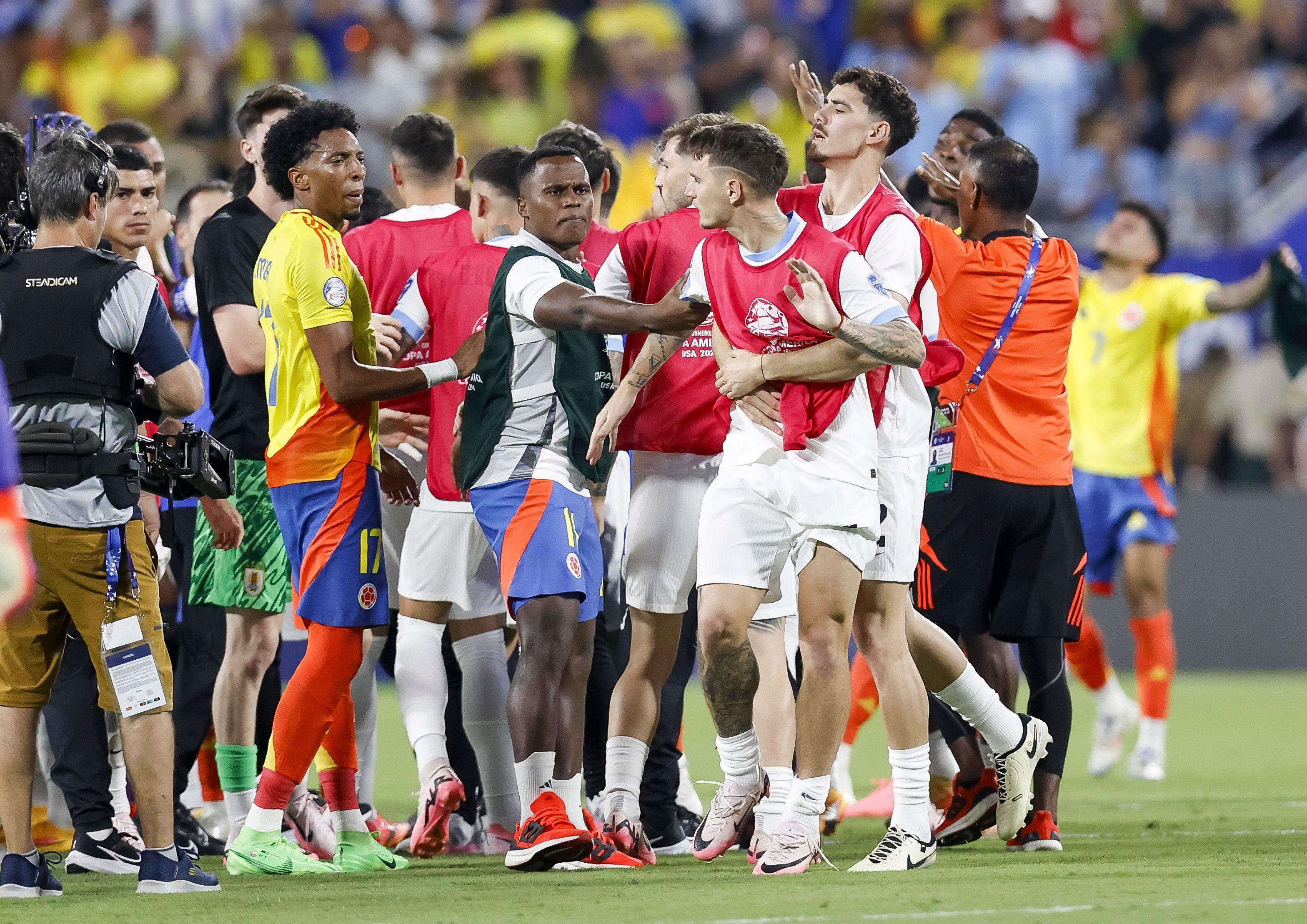 Jugadores uruguayos y colombianos son separados en la cancha tras el final del partido