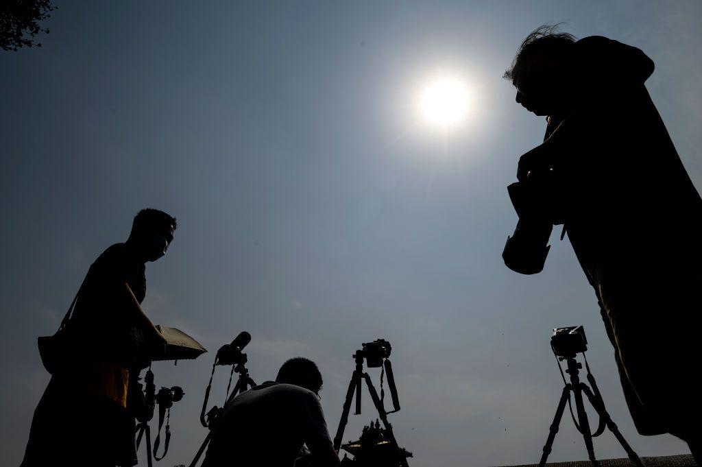 Un grupo de fotógrafos detallan el eclipse.