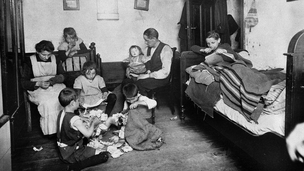 Esta imagem mostra uma família pobre vivendo em condições precárias em Berlim durante a década de 1920