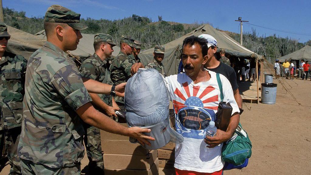 Un soldado estadounidense junto a un migrante en el centro de migrantes de Guantánamo.