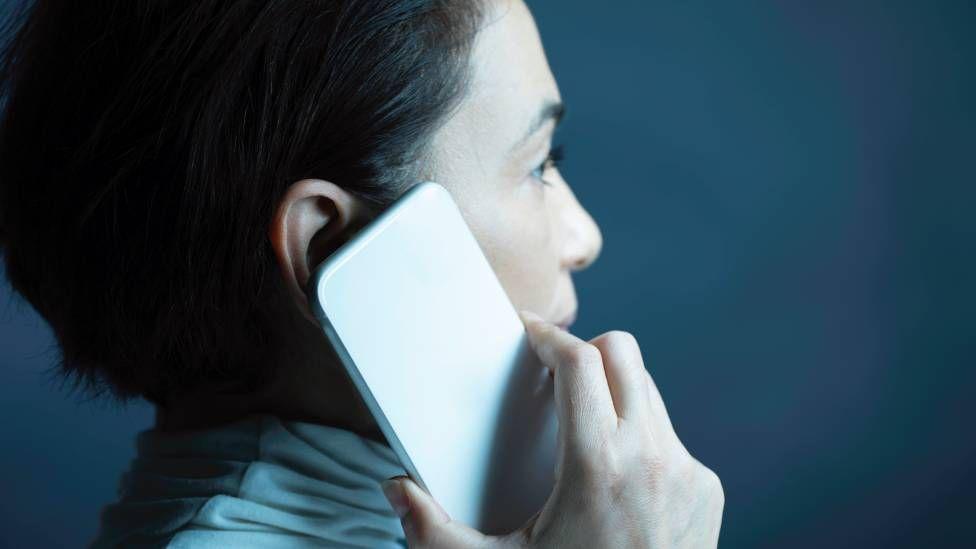 Mujer con el celular junto a la oreja