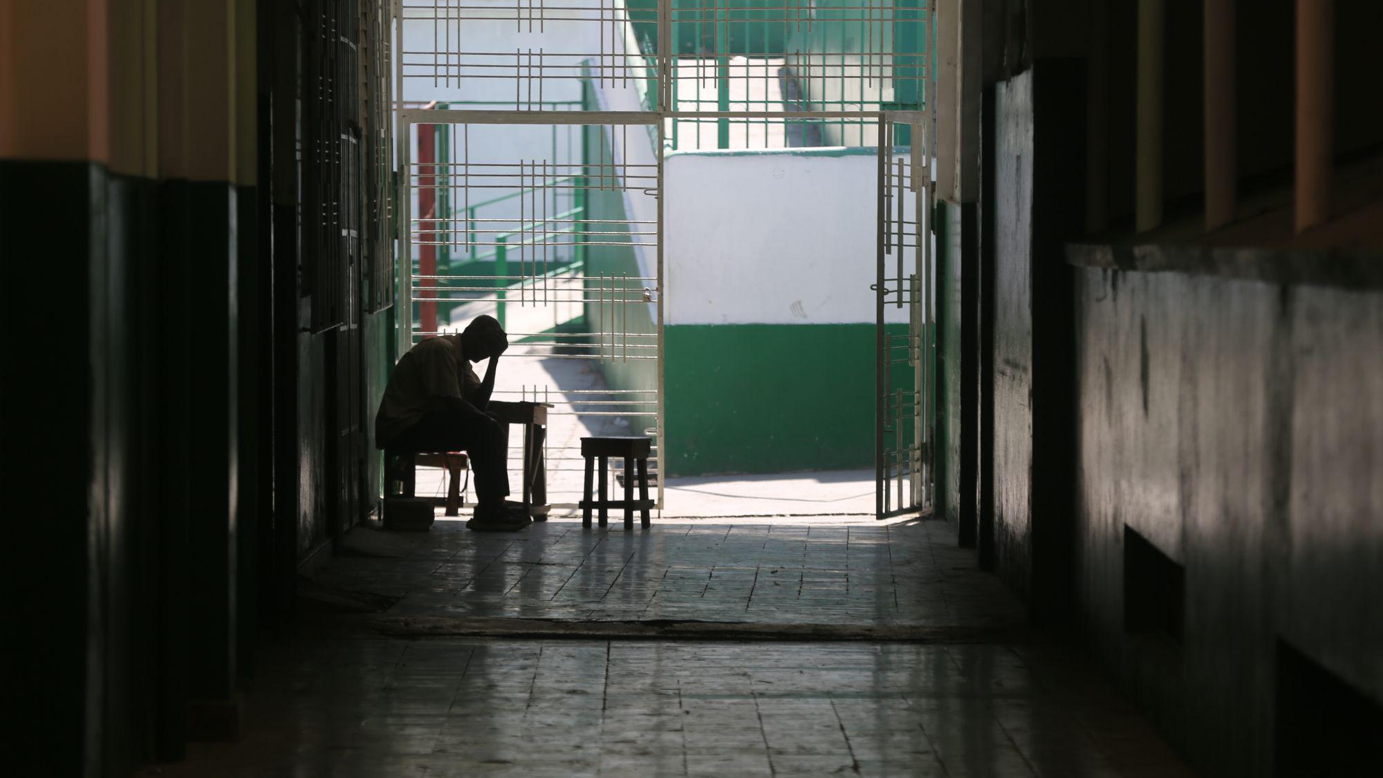 Homem sentado ao lado da porta do hospital