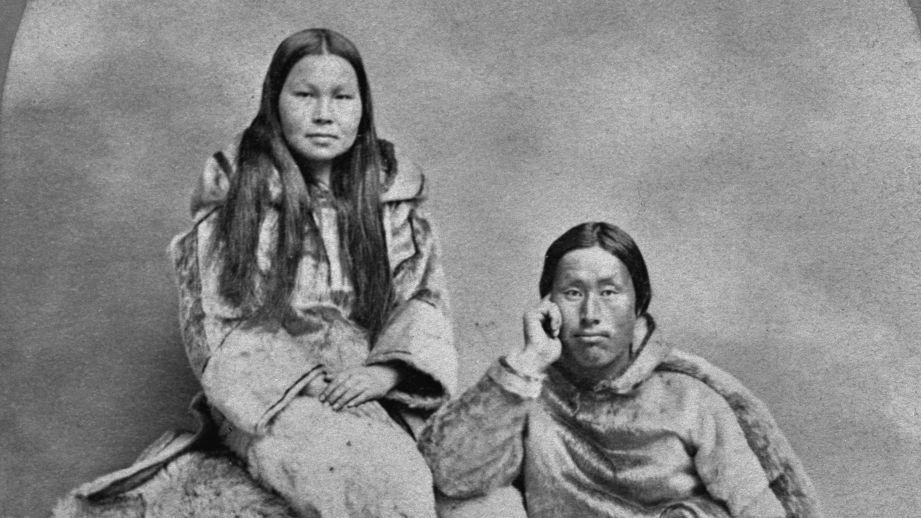 Una mujer inuit groenlandesa, sentada sobre un montón de pieles de animales junto a su marido, un jefe inuit groenlandés. Noroeste de Groenlandia, hacia 1865.