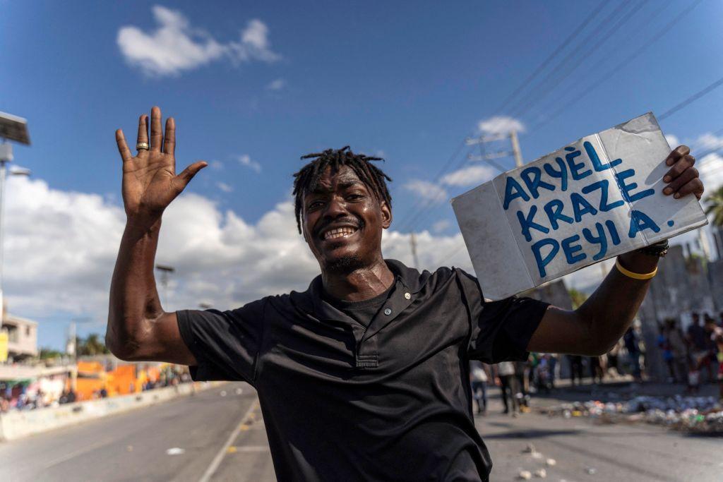 Un hombre lleva un cartel que dice "Ariel arruinó el país" en una protesta contra el primer ministro haitiano. 