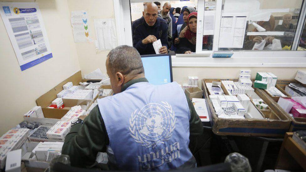 موظف بالأونروا يقدم المساعدة الطبية للفلسطينيين
