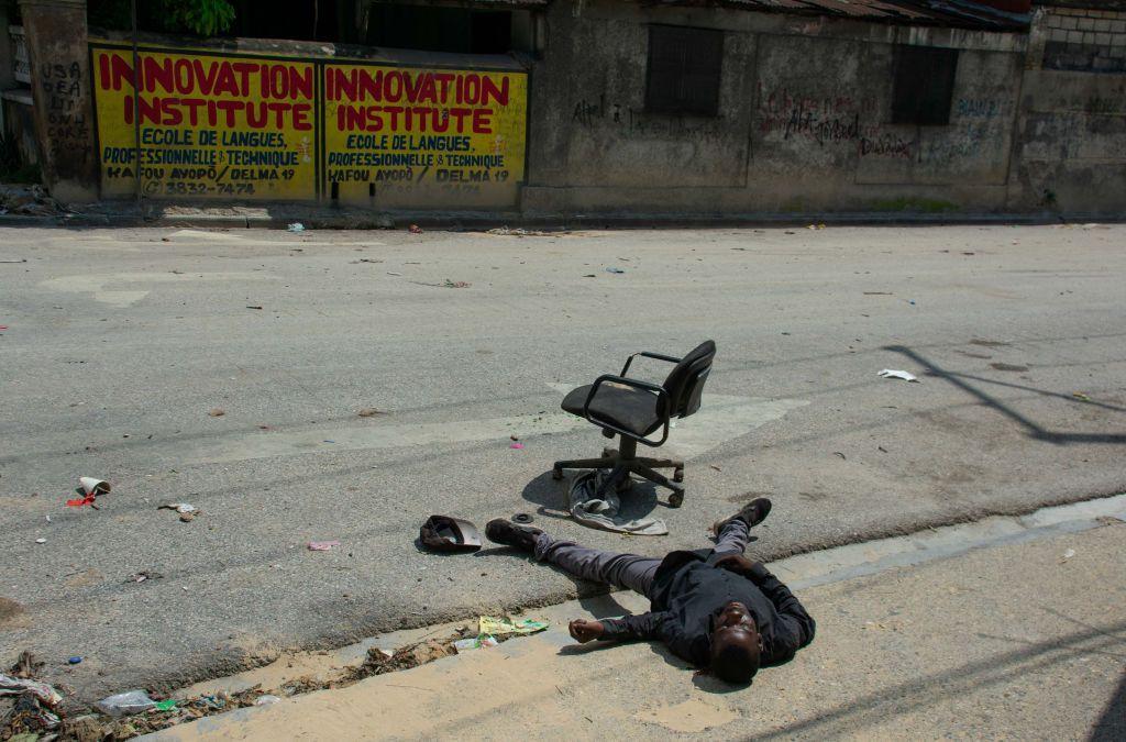 El cuerpo de un hombre tirado en el borde de una calle vacía junto a una silla de oficina abandonada, en el centro de Puerto Príncipe, Haití, el 24 de mayo de 2024.