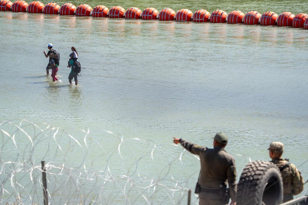 Migrantes cruzando el río Bravo.