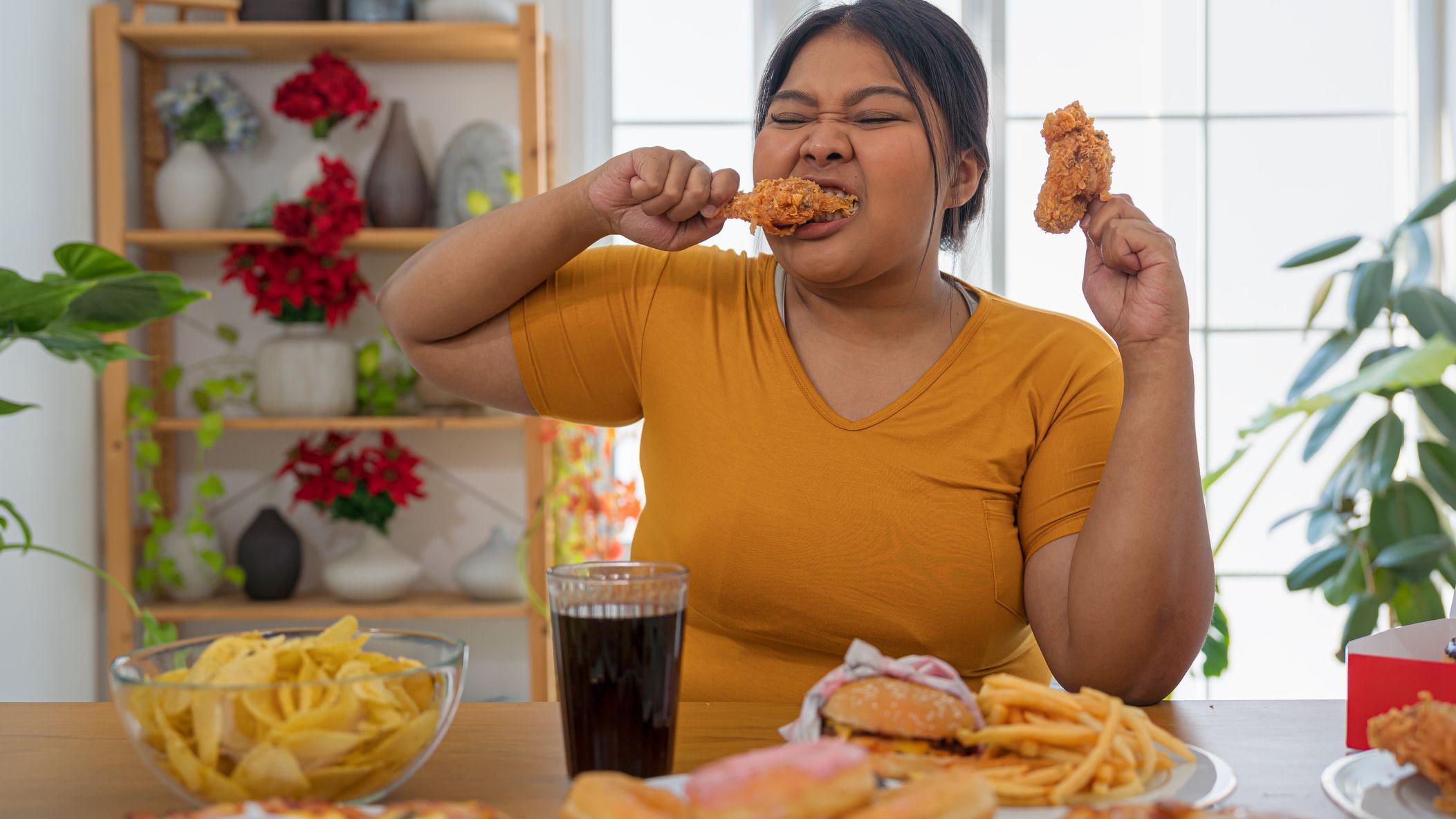 Una niña comiendo todo tipo de comida chatarra