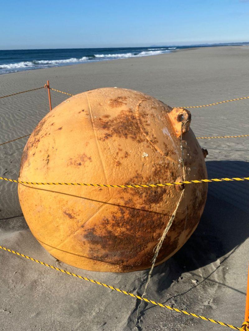 Esfera metálica na areia da praia