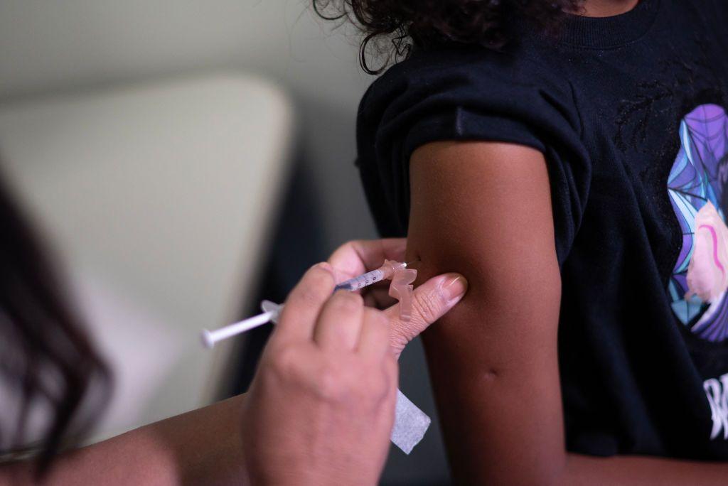 Criança recebendo vacina no braço 