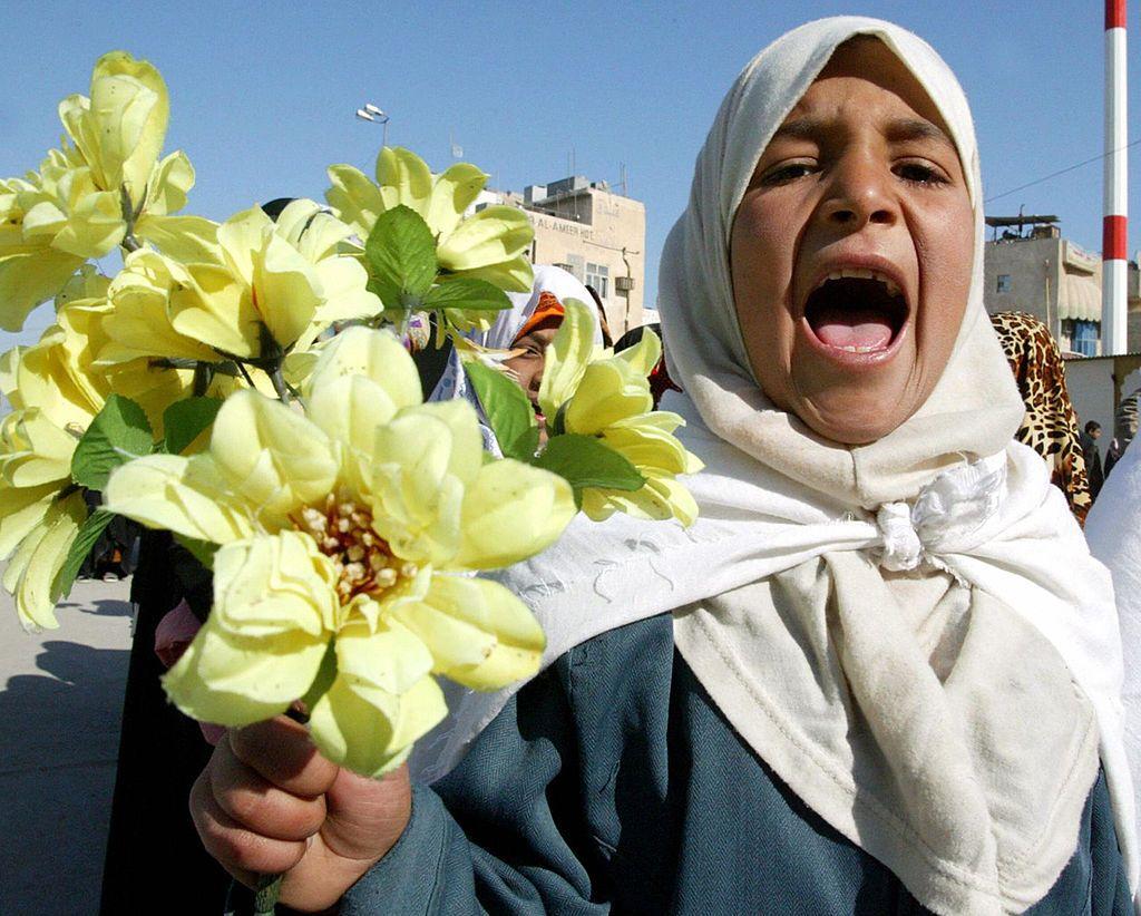 طفلة عراقية تحمل وروداً صفراء