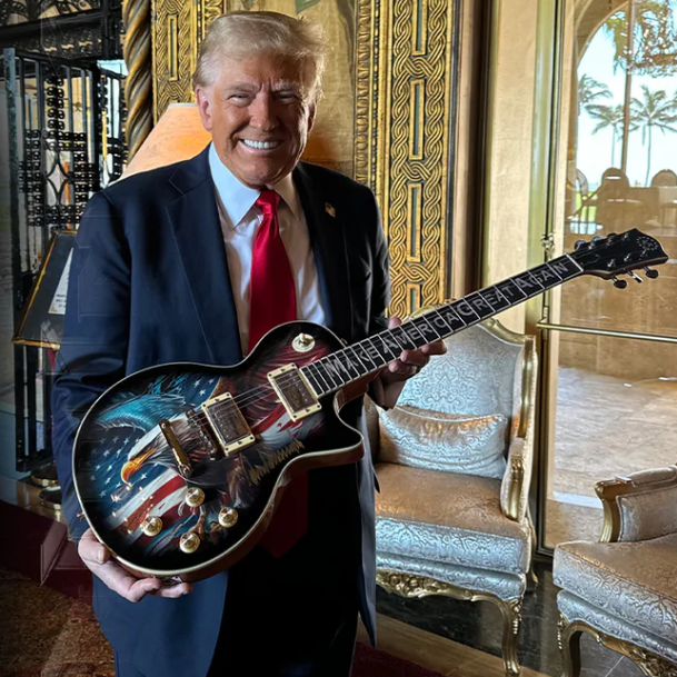 Trump segura guitarra endossada por ele 