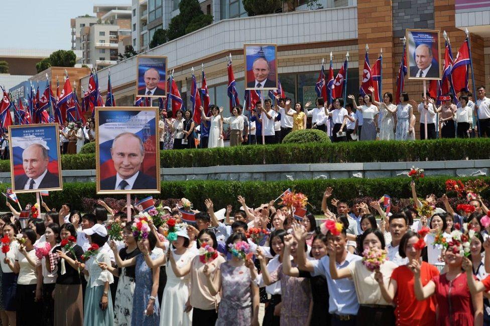 Una multitud con flores y fotos grandes del presidente de Rusia, Vladimir Putin