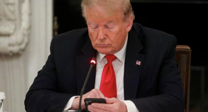 Donald Trump viendo su teléfono celular