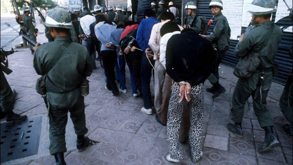 Militares llevan a un grupo de manifestantes detenidos