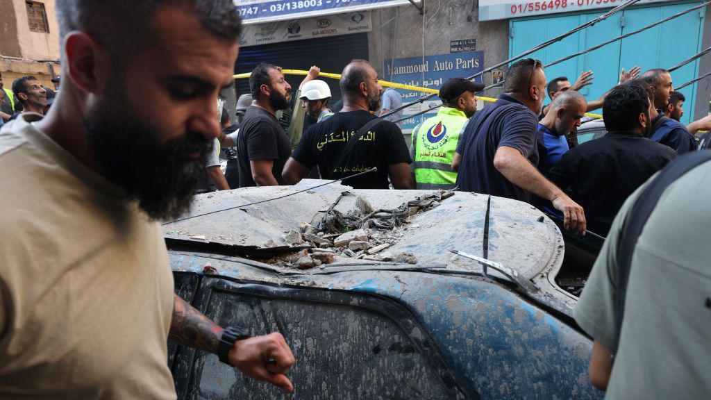 La gente mira la destrucción dejada por un ataque israelí en el área de Ghobeiri, en los suburbios del sur de Beirut, el 24 de septiembre de 2024.