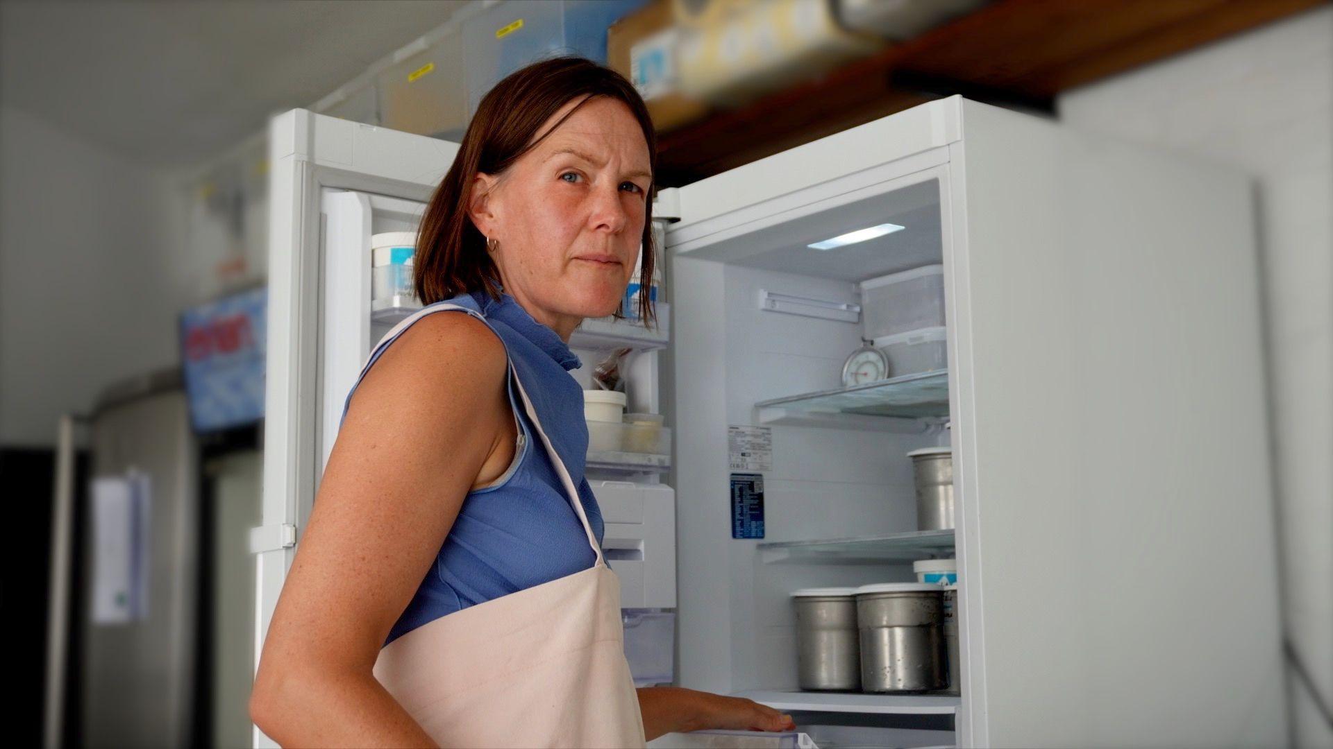 A sorveteira londrina Kitty Travers está em frente a um freezer aberto