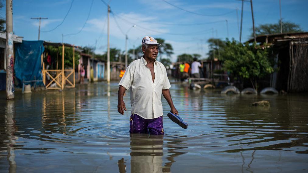 Un hombre camina por una calle inundada de Piura, en el norte de Perú