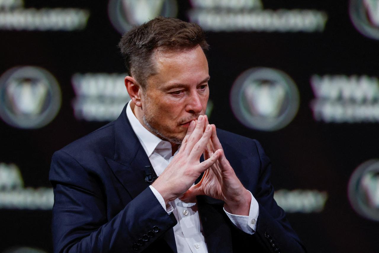 Elon Musk en posición pensativa durante una conferencia. 