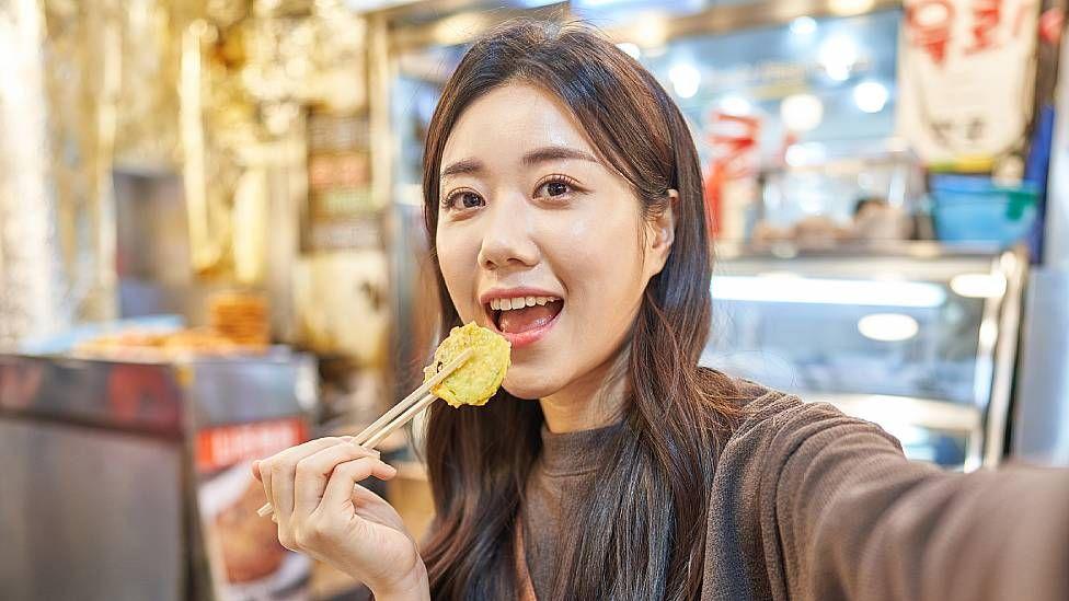 Joven comiendo en un mercado