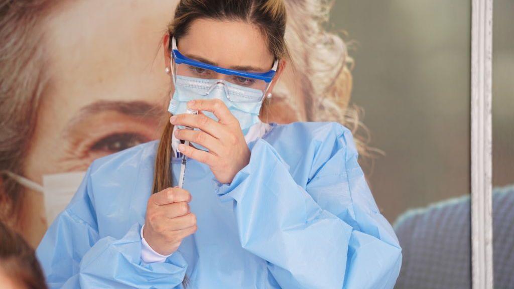 Doctora prepara dosis de vacuna en Colombia durante la pandemia de coronavirus. 