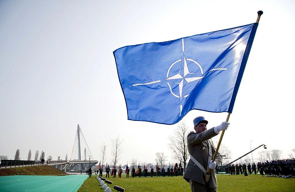 un soldado sostiene una bandera de la otan 