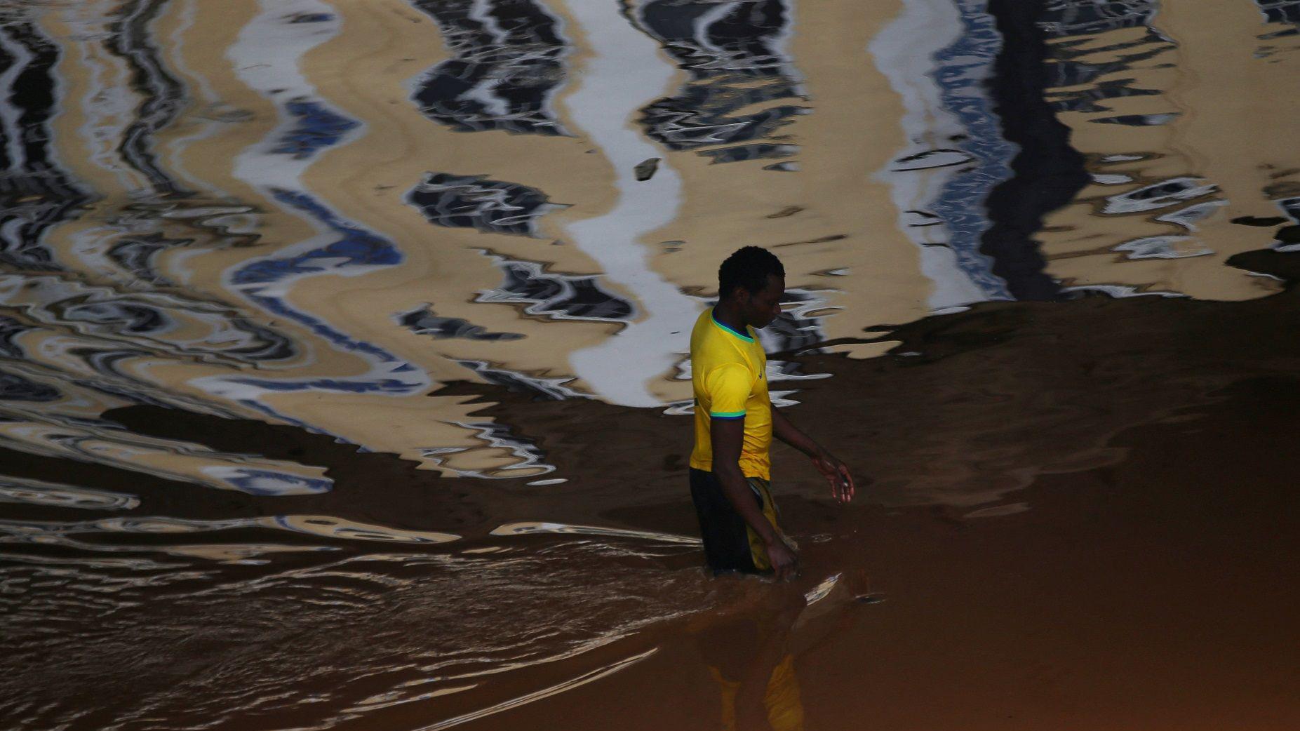 Um homem caminha em uma rua inundada no centro da cidade após a evacuação de pessoas em Porto Alegre, Rio Grande do Sul, Brasil, em 5 de maio de 2024.