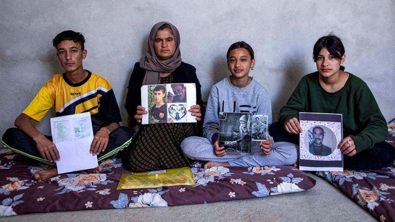 Abril de 2023: Bahar e seus três filhos seguram fotos de seus parentes desaparecidos.