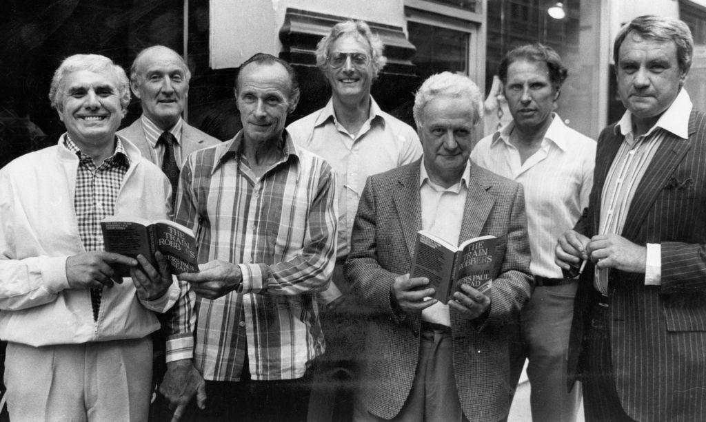 Os autores do assalto ao trem pagador com cópias do livro que escreveram em 1979. Da esquerda para a direita: Buster Edwards, Tom Wisbey, Jim White, Bruce Reynolds, Roger Cordrey, Charlie Wilson e Jim Hussey