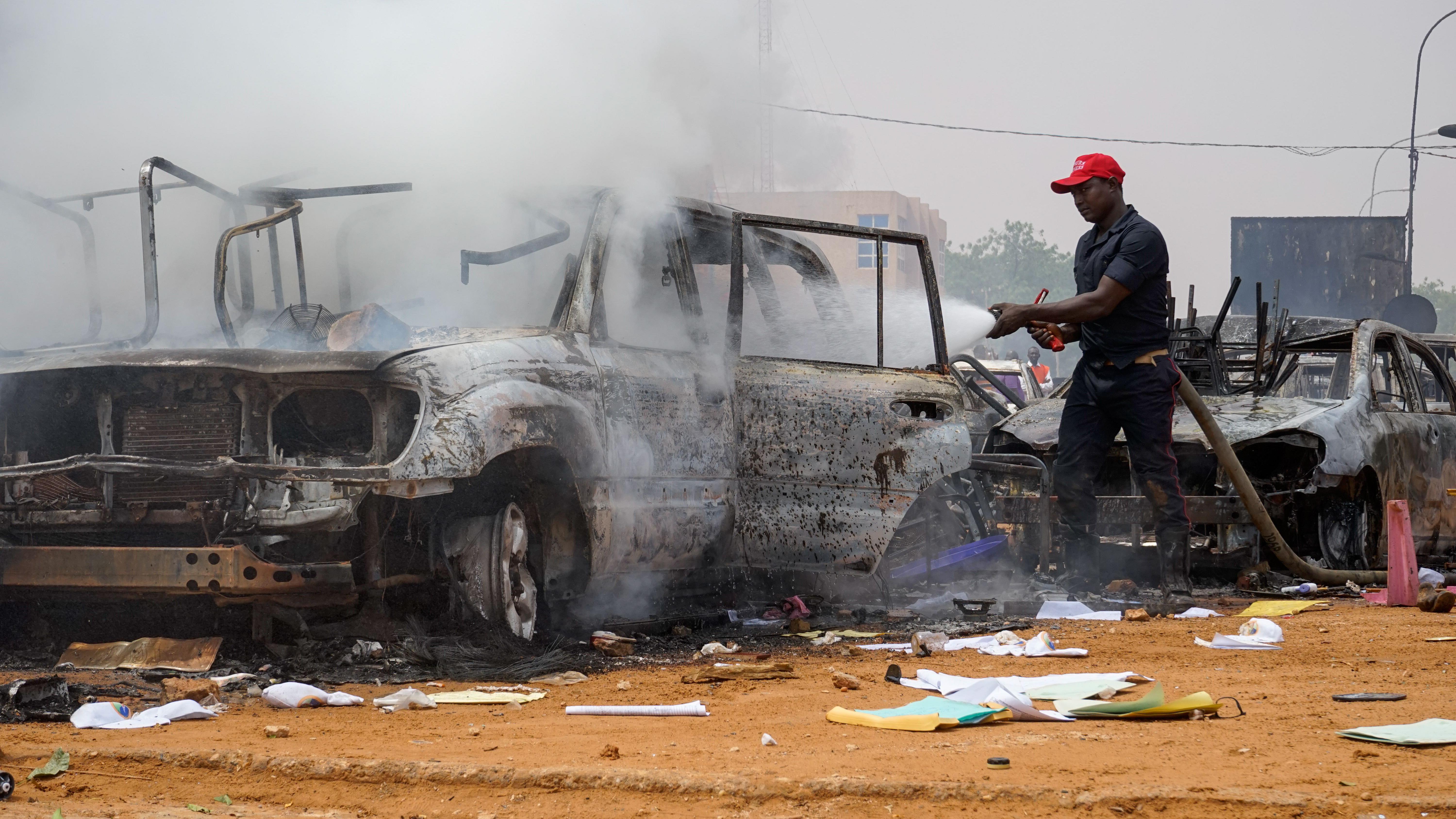رجل إطفاء يطفئ سيارات بالقرب من مقر الحزب النيجري من أجل الديمقراطية والاشتراكية في نيامي، النيجر، 27 يوليو/تموز 2023.