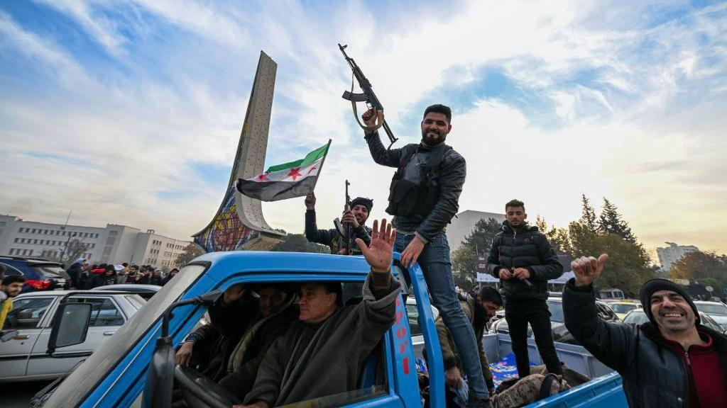 Rebeldes celebran la toma de Damasco en la plaza Omeya de la capital siria el domingo 8 de diciembre.