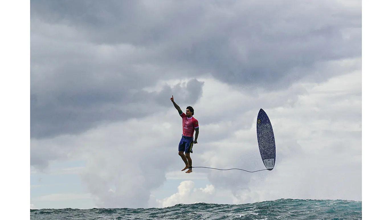 Surfer iznad vode sa daskom vezanom za nogu