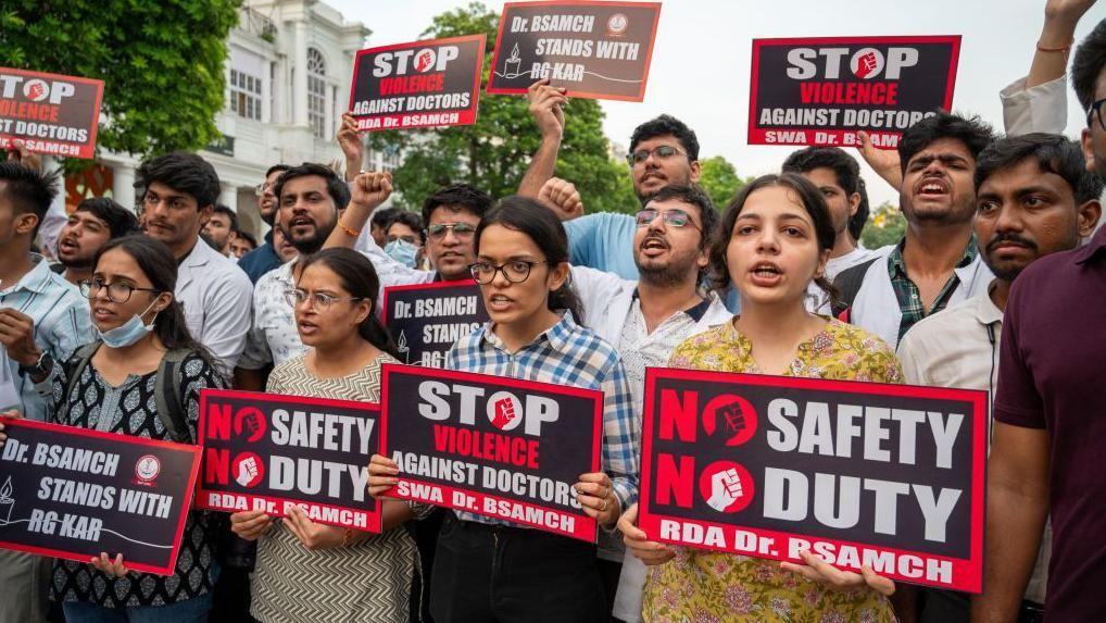 Para dokter memegang plakat bertuliskan 'No safety, no duty' sambil meneriakkan slogan-slogan selama demonstrasi terhadap pemerkosaan dan pembunuhan dokter peserta pelatihan pascasarjana.