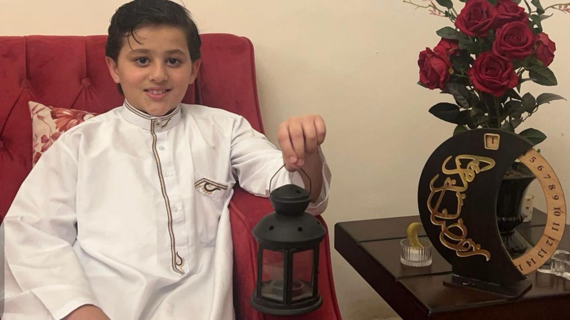 الطفل ليث يحمل فانوساً بيده.