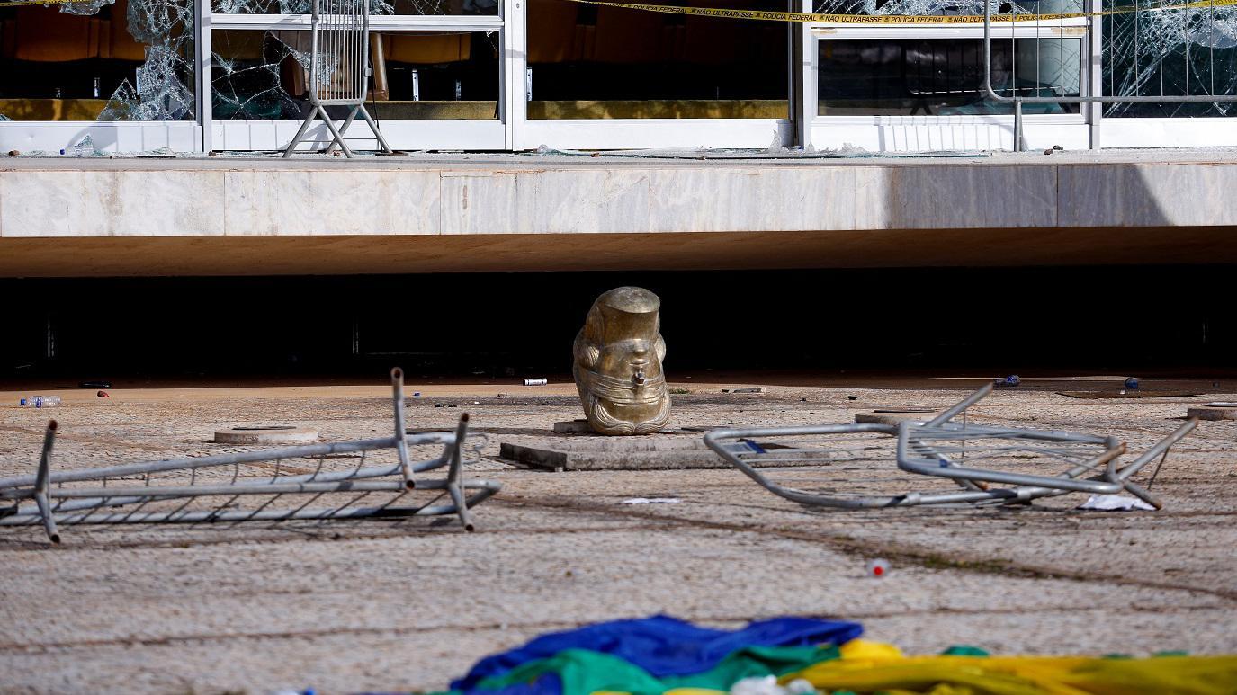 Cabeça de estátua de cabeça para baixo, em meio a destroços em frente ao STF 