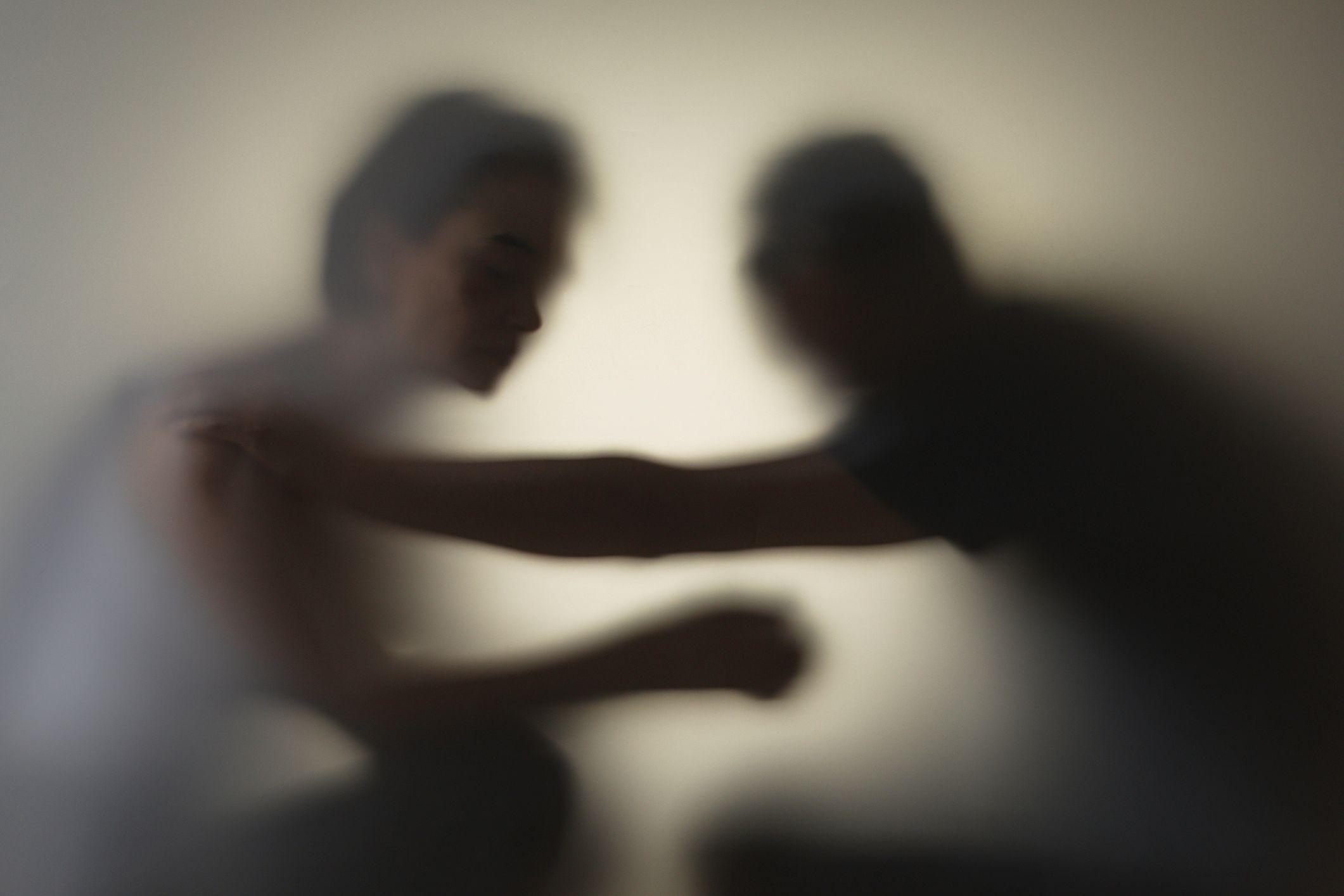 Sombra de homem e mulher brigando fisicamente