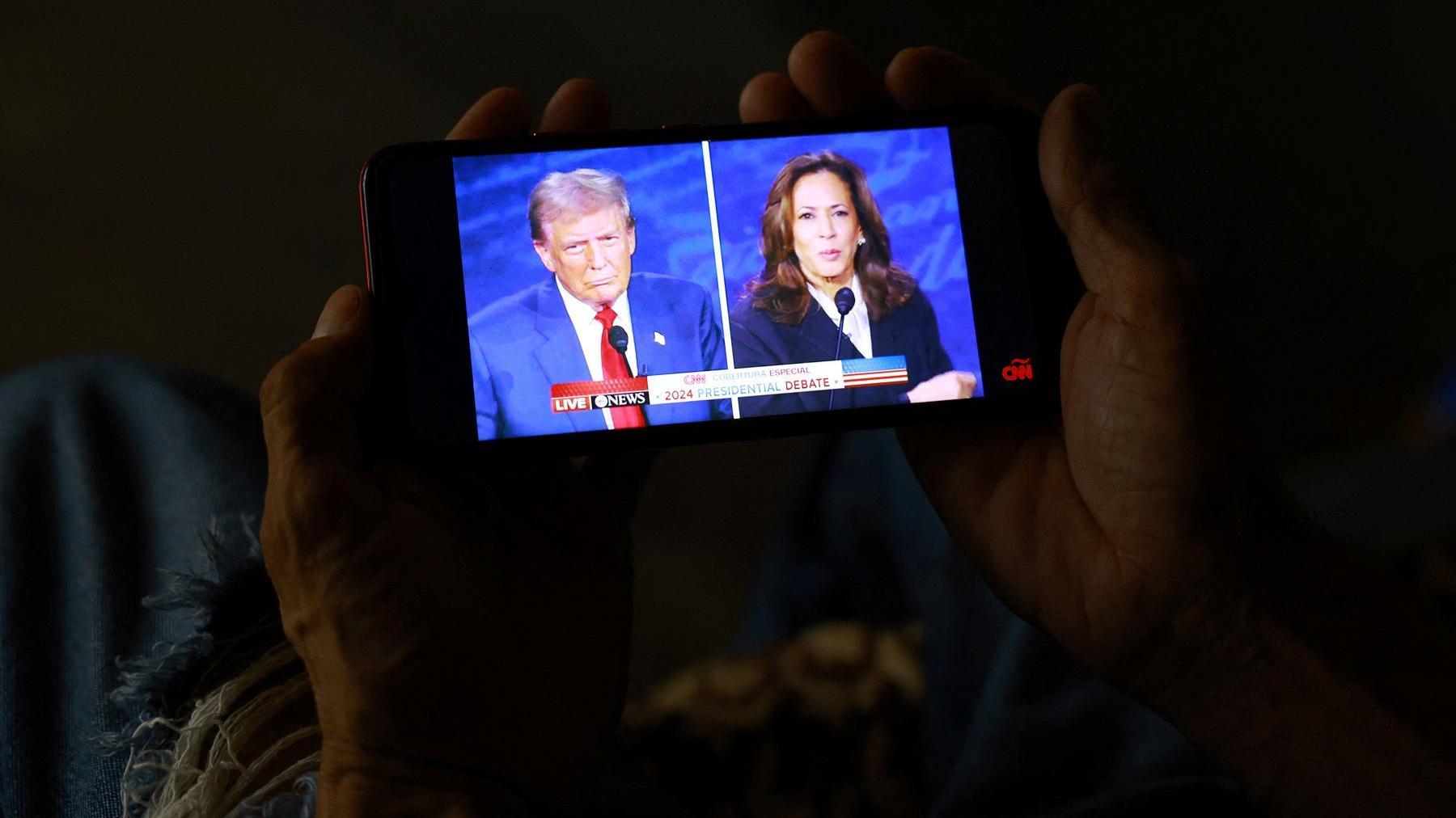 Trump e Kamala aparecem em debate na tela de um celular