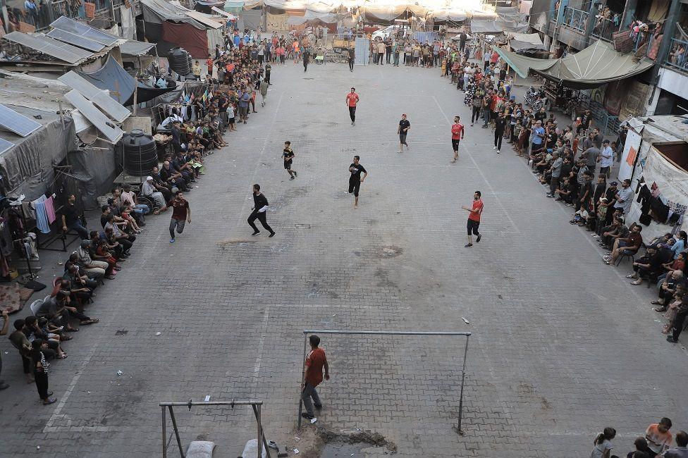 Jóvenes jugando fútbol en un patio

