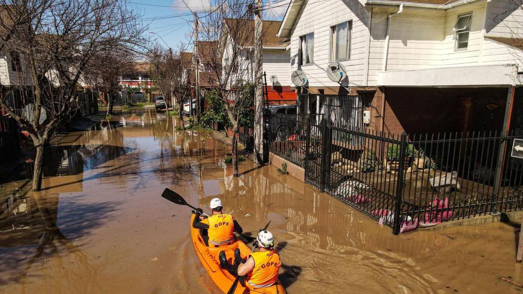 Um grupo de resgate de caiaque em uma rua inundada após fortes chuvas em Santa Cruz, Chile, em 23 de agosto de 2023