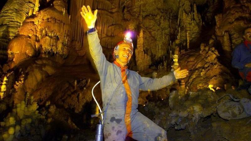 Homem branco com aparato de exploração dentro de caverna