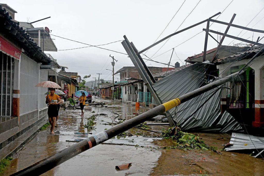 A group of women walk past damage to a street caused by Hurricane John in San Marcos, Guerrero state, Mexico, on September 24, 2024.