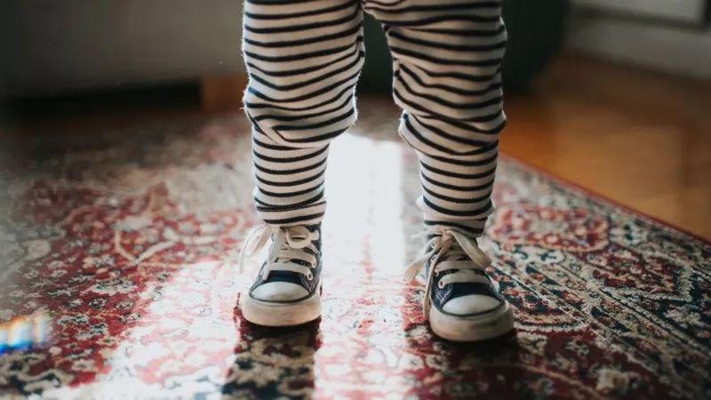 Pernas de um bebê de pé