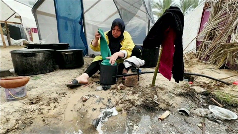 Uma Shadi washing clothes near the tents 