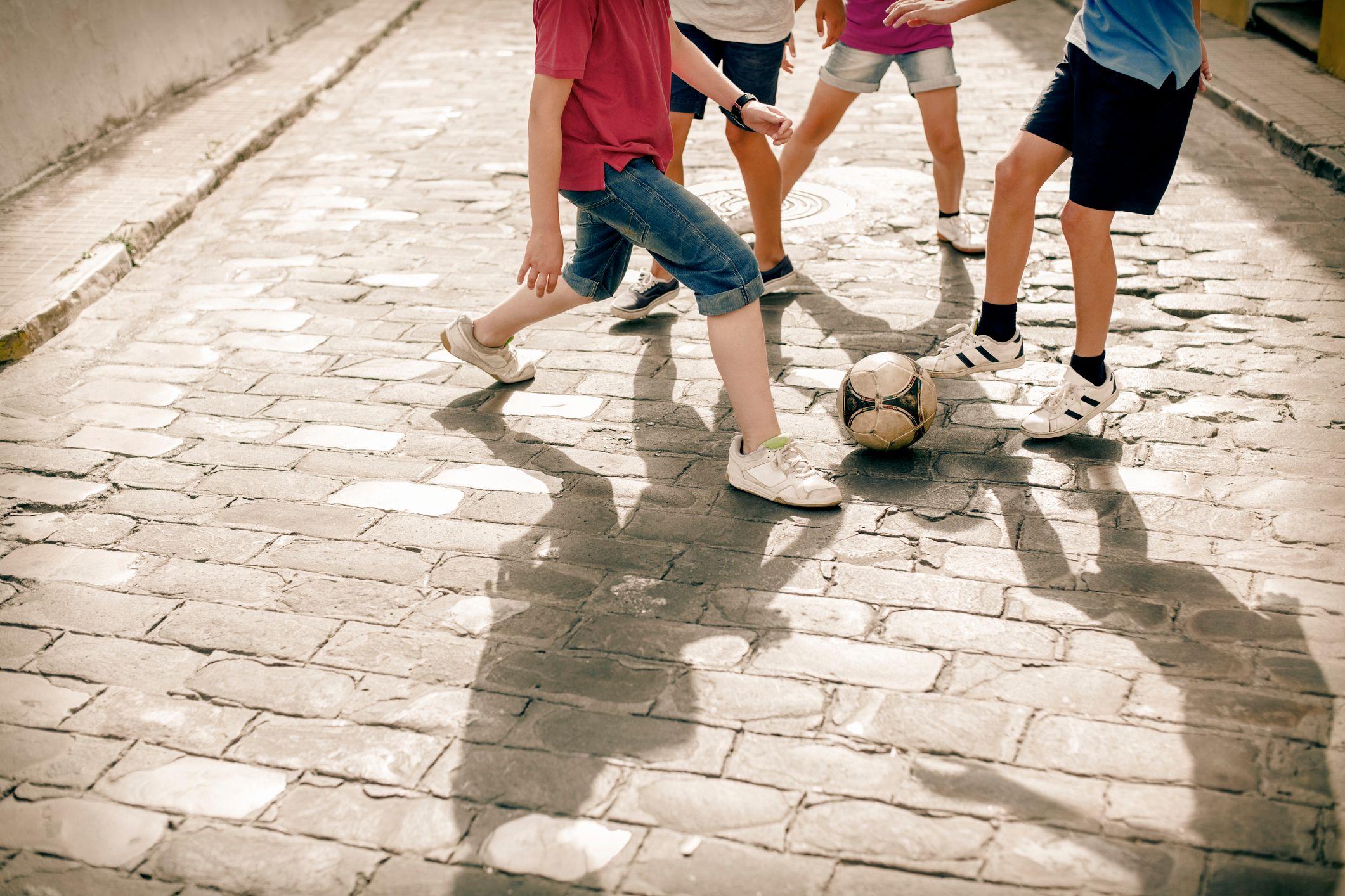 Niños jugando fútbol en la calle 
