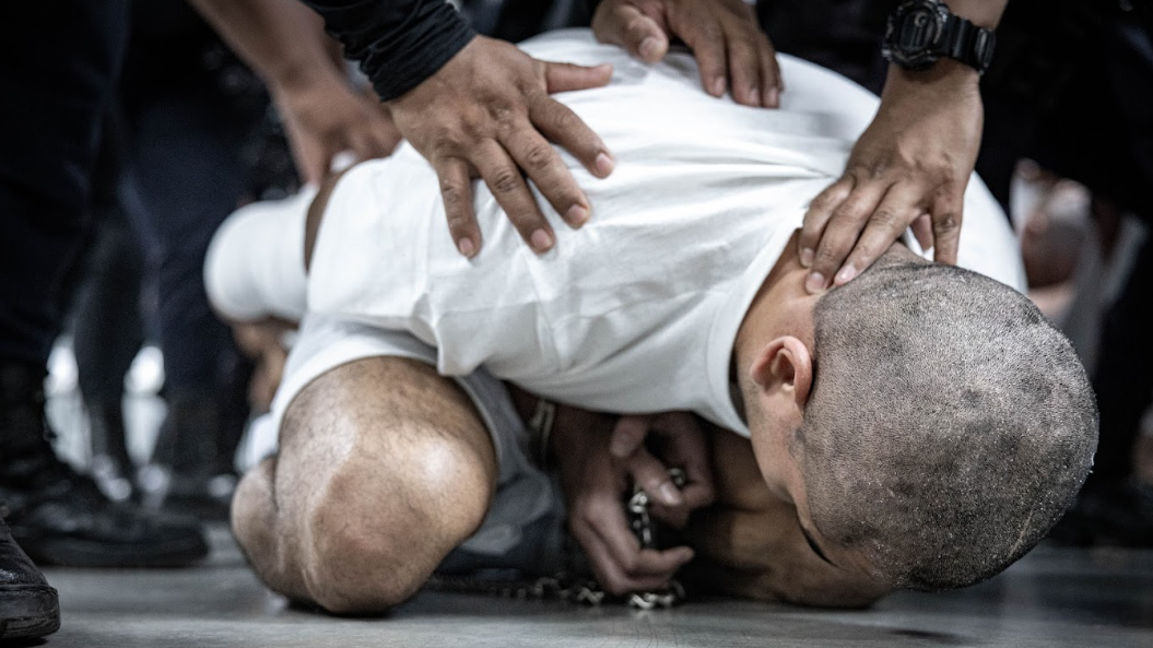 Un deportado de Estados Unidos, presuntamente vinculado a una organización criminal, agachado y sometido por agentes en el Centro de Confinamiento de Terrorismo (Cecot), en Tecoluca, El Salvador, el 16 de marzo de 2025. Foto: cortesía del gobierno de El Salvador vía Getty Images