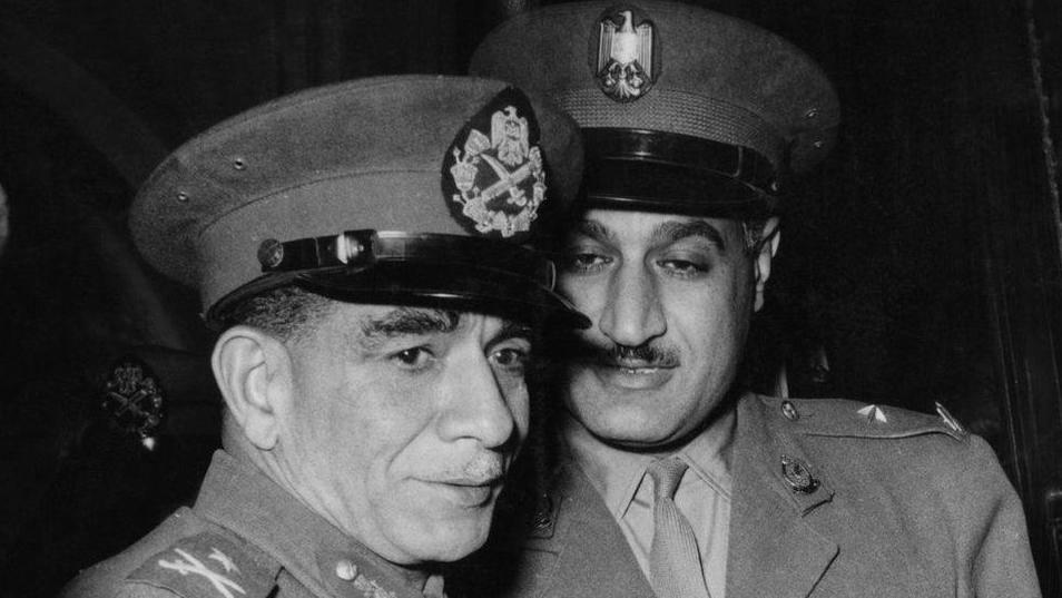 عبد الناصر( على اليمين) من السلطة بعد التخلص من اللواء محمد نجيب، أول رئيس لمصر بعد ثورة 23 يوليو/تموز، إثر صراع سعى خلاله نجيب إلى إقرار الديمقراطية.