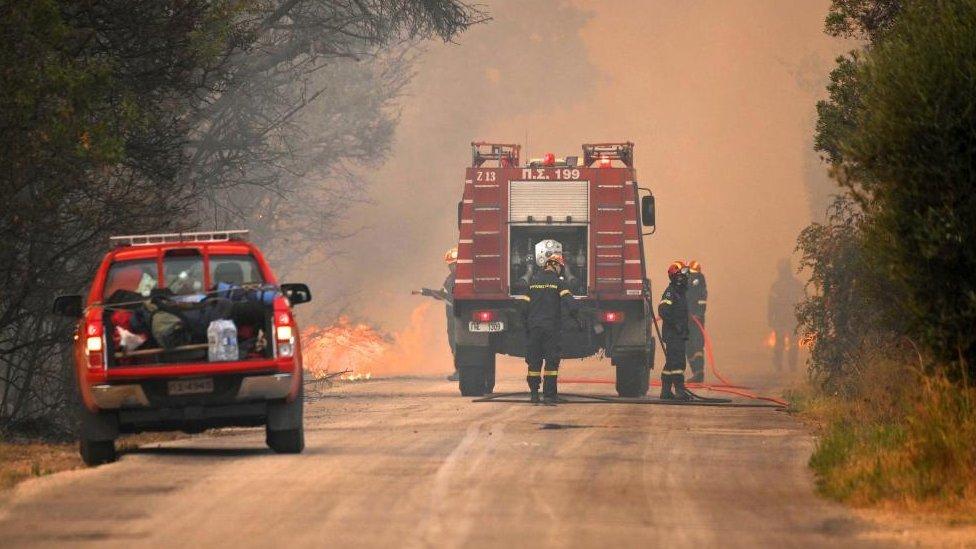 Dos vehículos de los bomberos de Grecia en un camino. 