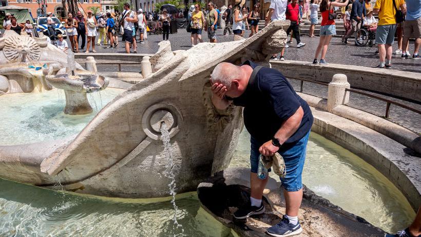 ينعش السائحون أنفسهم بالمياه من نافورة باركاتشيا في ساحة إسبانيا في روما خلال موجة الحر المستمرة في 17 يوليو/ تموز 2023.