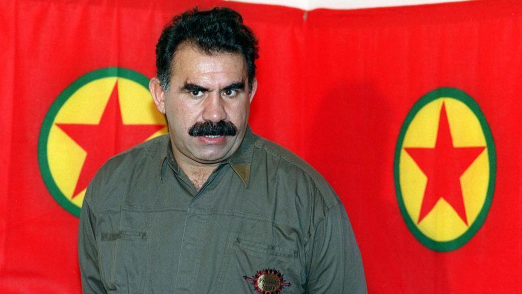 Abdalá Ocalan delante de la bandera del PKK